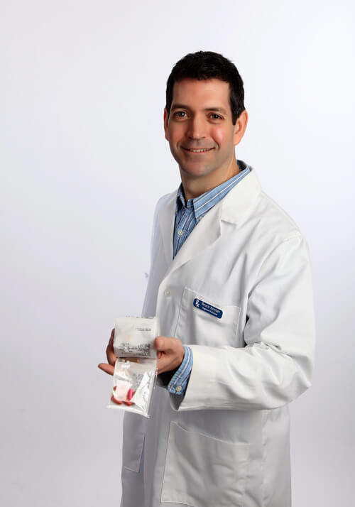 Pharmacist Bruce Kocian at Gibson Pharmacy holding a SyncRx personalized medication pack